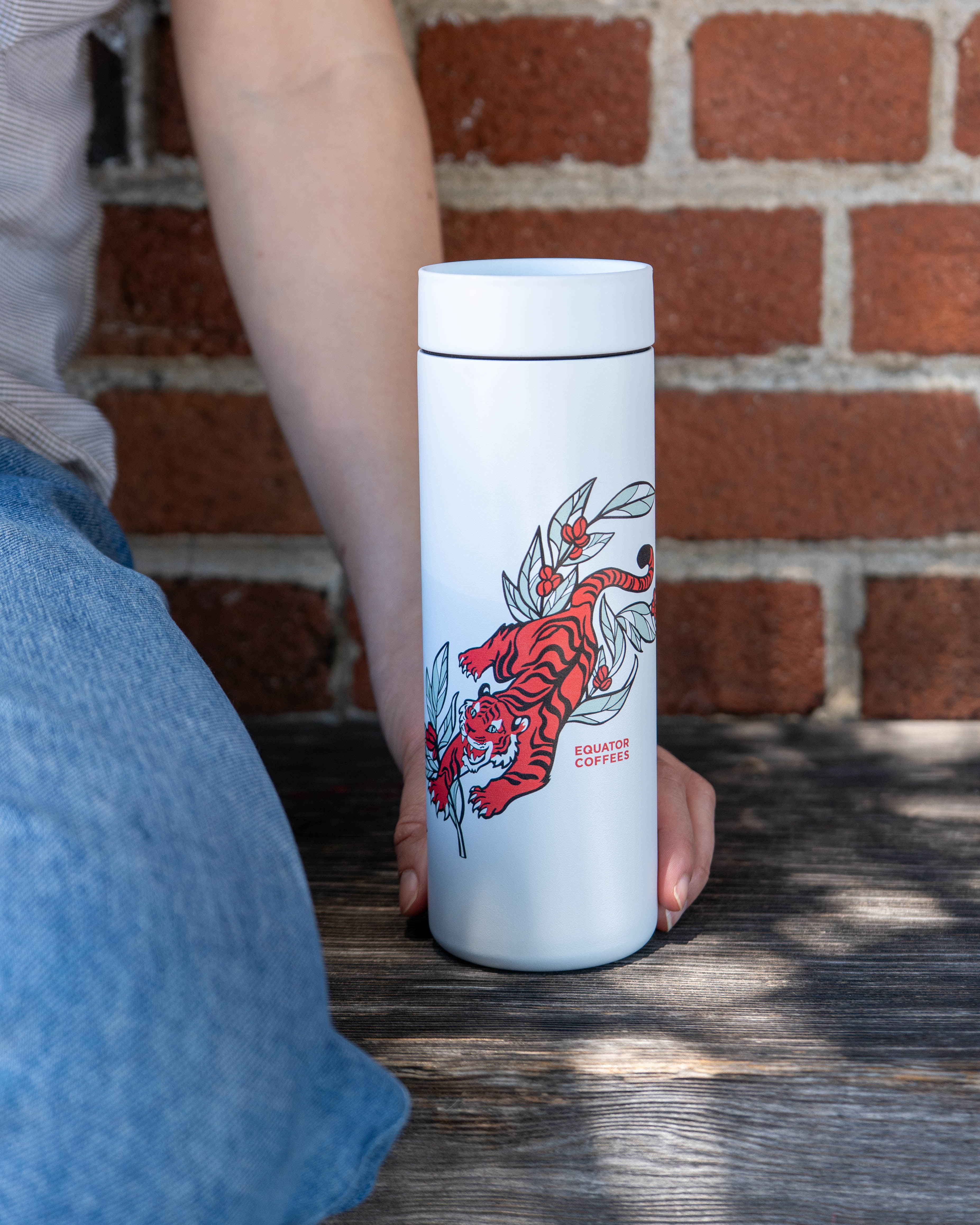 Harvest Tiger tumbler against a brick wall | Equator Coffees