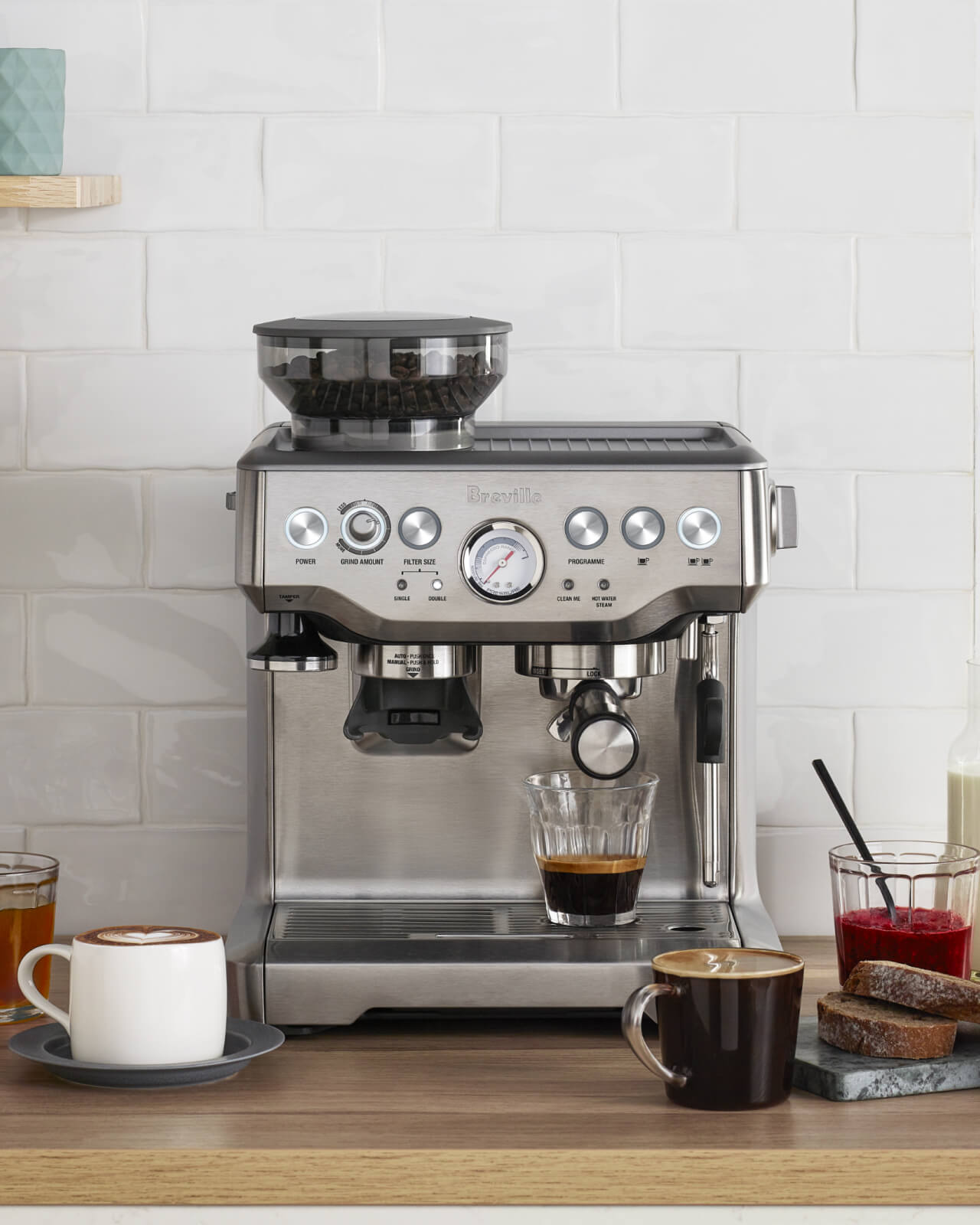 The Breville Barista Express Espresso Machine pulling a shot of espresso on the kitchen counter | Equator Coffees