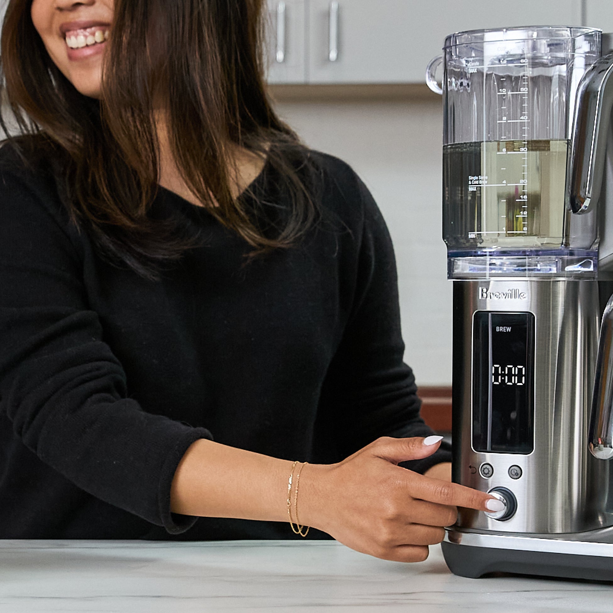 Person using a Breville coffee maker in a kitchen setting