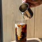 Adding cream to a cold brew coffee on a hot day | Equator Coffees