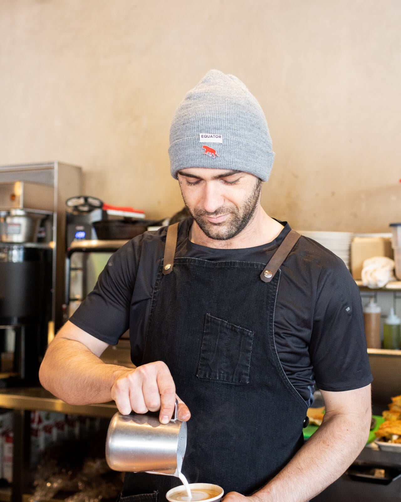 Equator Grey Tab Beanie | Grey Winter Beanie | Equator Barista wearing a grey beanie | Equator Coffees