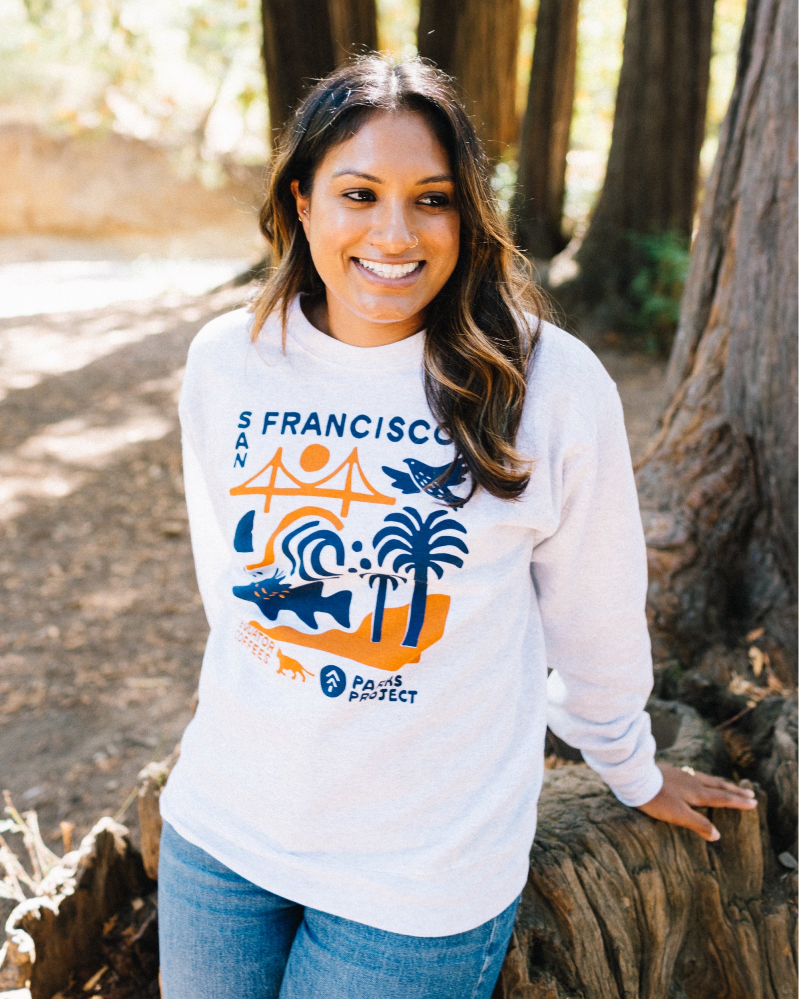 Woman wearing a white Parks Project x Equator Coffees sweatshirt | Equator Coffees