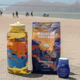 Golden Hour x Buoy Hydration Bundle agains a scenic beach background | Equator Coffees