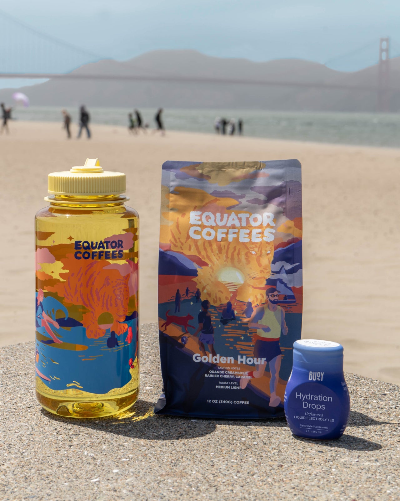 Golden Hour x Buoy Hydration Bundle agains a scenic beach background | Equator Coffees
