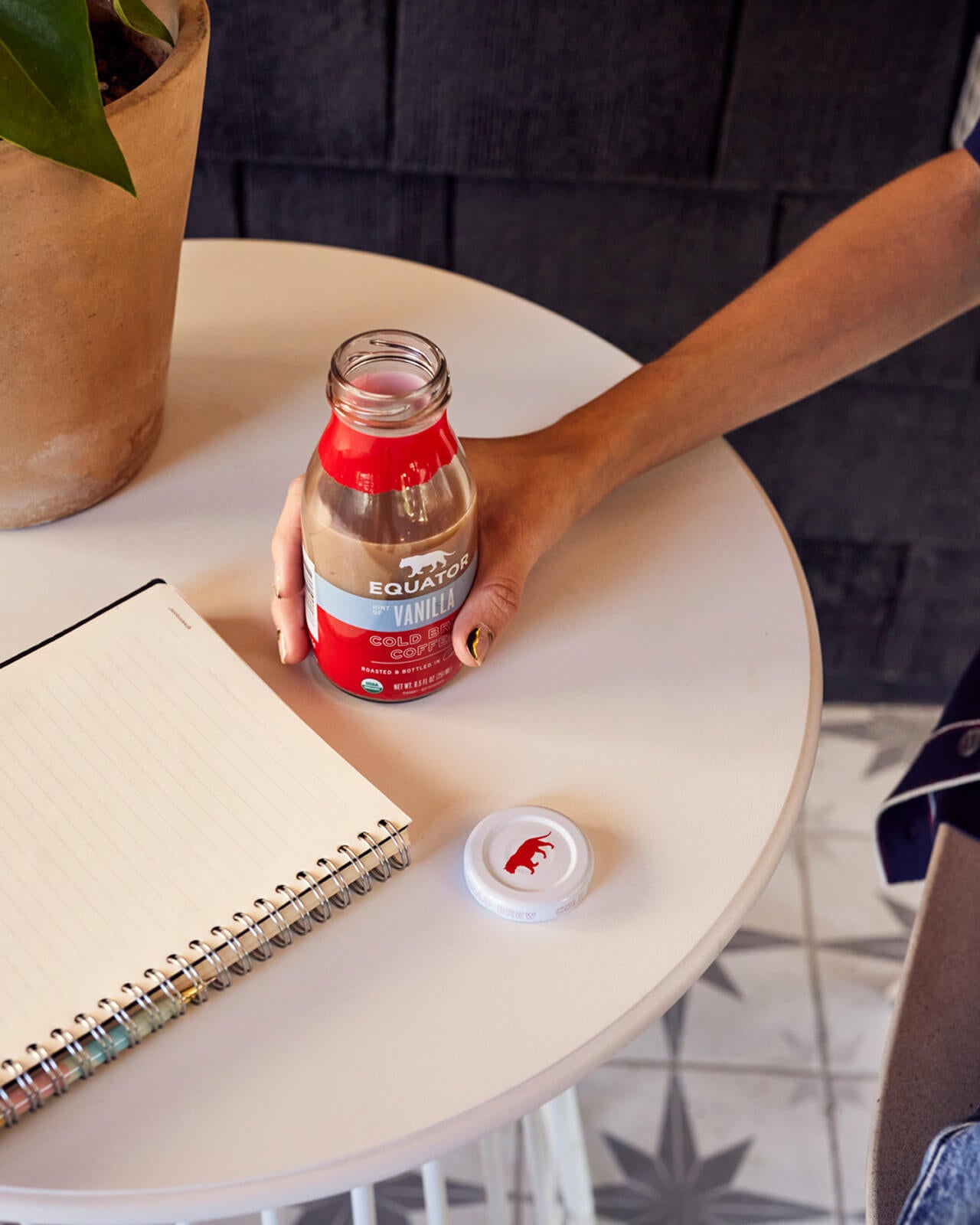 Opening up a refreshing bottle of Hint of Vanilla Organic Cold Brew Coffee tfor an outdoor study session | Equator Coffees