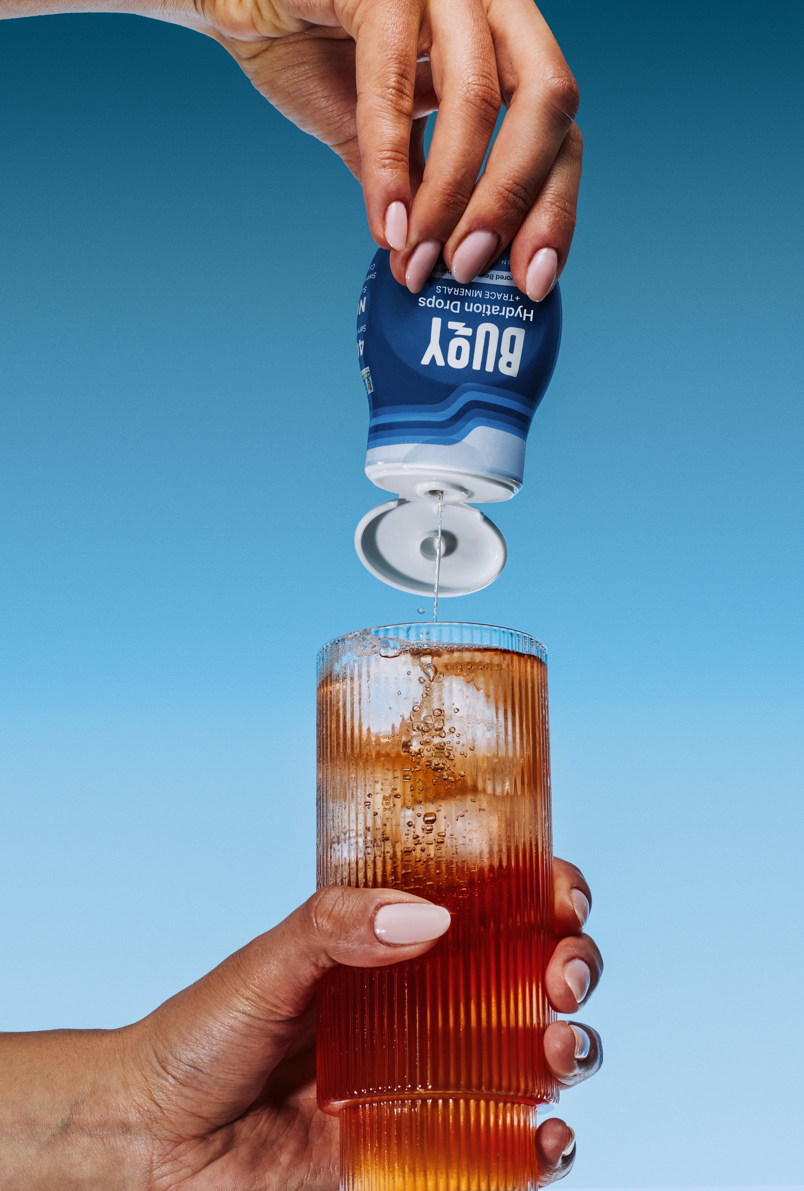 Buoy Hydration Drops with a glass of iced tea