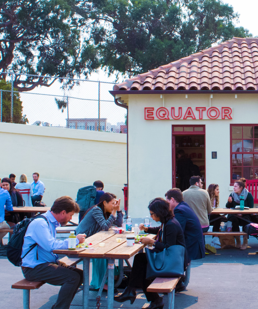 People sitting at outdoor tables in front of Equator Coffees | Equator Coffees